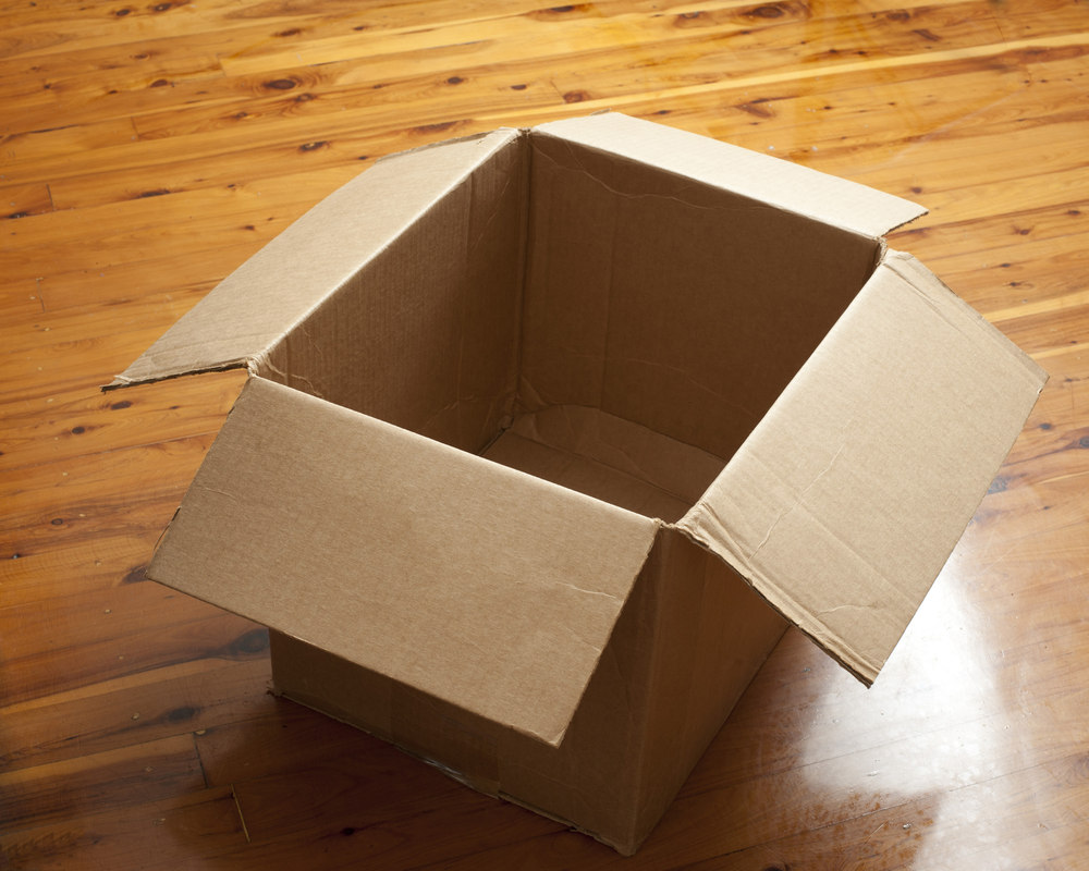Open cardboard box on a floor; not an exam or classroom scene